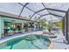 Expansive screened-in lanai with a pool, spa, outdoor kitchen and ample seating at 7108 Harle Ave, North Port, FL 34291