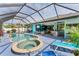 Relaxing pool and spa area with a large screened enclosure and outdoor lounge chairs at 7108 Harle Ave, North Port, FL 34291