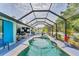 Gorgeous screened-in pool with spa, lounge area, outdoor kitchen, and lush landscaping at 7108 Harle Ave, North Port, FL 34291