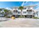 Beach house exterior featuring a sandy beach, elevated balconies, and staircase with palm trees at 7466 Palm Island Dr # 2913, Placida, FL 33946
