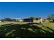 Home's backyard with a screened in lanai, surrounded by green grass, and golf course views at 81 Oakland Hills Pl, Rotonda West, FL 33947