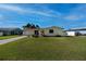 Inviting single-story yellow home featuring a lovely yard and a private driveway at 81 Oakland Hills Pl, Rotonda West, FL 33947