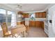 Charming kitchen with wood cabinets, white appliances, and a cozy dining area with natural light at 81 Oakland Hills Pl, Rotonda West, FL 33947