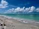 A picturesque beach with soft sand, turquoise water, and fluffy white clouds in the blue sky at 8714 King St, Placida, FL 33946