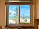 Breathtaking beach view framed by a window, showcasing palm trees, white sands, and clear blue skies at 8714 King St, Placida, FL 33946