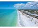 Panoramic aerial view of beachfront community with beautiful beach, turquoise water, and homes lining the sandy shore at 8812 Grand Ave, Placida, FL 33946