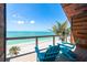 Balcony view with relaxing Adirondack chairs and stunning ocean and beach views on a sunny day at 8812 Grand Ave, Placida, FL 33946