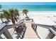 Pathway of outdoor stairs leads down to a gorgeous beach with palm trees and sparkling ocean views at 8812 Grand Ave, Placida, FL 33946