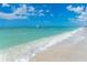 Scenic beach view showcasing turquoise water, gentle waves, and clear blue sky with scattered clouds at 8812 Grand Ave, Placida, FL 33946