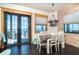 Dining room featuring a rustic chandelier, brick accent wall and a view of the ocean through the sliding glass door at 8812 Grand Ave, Placida, FL 33946