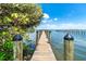 A long wooden dock extends into the bay with scenic water views and beautiful blue skies at 8812 Grand Ave, Placida, FL 33946