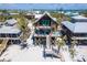 Stunning raised beach house with wood siding, dual balconies, and steps down to the sandy beach at 8812 Grand Ave, Placida, FL 33946