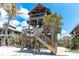 Beach house featuring rustic wood facade, elevated construction, and easy beach access via wooden stairs at 8812 Grand Ave, Placida, FL 33946