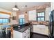 A kitchen area with white cabinets, stainless steel appliances, black countertop and view of water out the window at 8812 Grand Ave, Placida, FL 33946