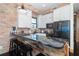 A kitchen area with white cabinets, stainless steel appliances, black countertop and breakfast bar with seating at 8812 Grand Ave, Placida, FL 33946