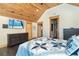 A spacious main bedroom offers wood ceiling, hardwood floors, and a TV for relaxing evenings at 8812 Grand Ave, Placida, FL 33946