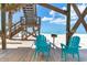 Outdoor living space with chairs, grill, and a path that leads down to a sandy beach at 8812 Grand Ave, Placida, FL 33946