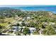 Aerial view of neighborhood with waterfront in distance and many surrounding trees at 941 Elwood Ave, Englewood, FL 34223