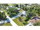Aerial view of a charming home with a lush green lawn and mature trees in a quiet neighborhood at 941 Elwood Ave, Englewood, FL 34223