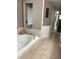Relaxing bathroom featuring a large soaking tub with stylish tile surround and neutral colors at 941 Elwood Ave, Englewood, FL 34223