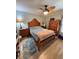 Cozy bedroom with wood furniture, ceiling fan and neutral colored walls and floor tiles at 941 Elwood Ave, Englewood, FL 34223