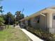 Exterior home side featuring vinyl siding, open windows, and gated backyard at 941 Elwood Ave, Englewood, FL 34223