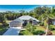 Charming home featuring a meticulously manicured lawn, lush tropical landscaping, and a welcoming two-car garage at 941 Elwood Ave, Englewood, FL 34223