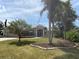 Landscaped front yard showcasing flowering plants, mature palm trees, and a well-maintained lawn, enhancing curb appeal at 941 Elwood Ave, Englewood, FL 34223