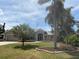 Landscaped front yard showcasing flowering plants, mature palm trees, and a well-maintained lawn, enhancing curb appeal at 941 Elwood Ave, Englewood, FL 34223