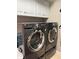 Efficient laundry room with modern gray front-load washer and dryer and plenty of storage at 941 Elwood Ave, Englewood, FL 34223