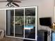 Covered patio has sliding glass doors leading to screened in pool, with wet bar and TV at 941 Elwood Ave, Englewood, FL 34223