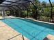 Screened-in pool with brick surround, waterfall feature and lush landscaping provides a relaxing outdoor oasis at 941 Elwood Ave, Englewood, FL 34223