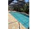 Screened-in pool with brick surround, waterfall feature and lush landscaping provides a relaxing outdoor oasis at 941 Elwood Ave, Englewood, FL 34223