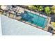 Aerial view of a screened-in pool with brick patio and tropical landscaping at 941 Elwood Ave, Englewood, FL 34223