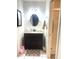 Bathroom featuring a modern vanity, decorative mirror, and tiled flooring for a clean look at 10275 Euston Ave, Englewood, FL 34224