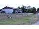 Home exterior featuring a well-maintained lawn and mature trees at 10275 Euston Ave, Englewood, FL 34224