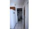Hallway leading to a storage room with white shelving, washer, and dryer at 10275 Euston Ave, Englewood, FL 34224