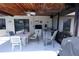 Spacious covered patio featuring a dining table, barbecue, bar and ceiling fan at 10275 Euston Ave, Englewood, FL 34224