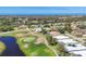 An aerial view of a residential community situated along a scenic golf course, showcasing houses, lush greenery, and water views at 105 Westwind Dr, Placida, FL 33946
