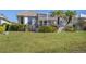 Exterior view of a backyard featuring lush grass, landscaping, palm trees, and a screened-in lanai for outdoor relaxation at 105 Westwind Dr, Placida, FL 33946
