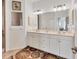 Bright bathroom showcases a dual sink vanity, decorative rug, large mirror, and neutral decor at 105 Westwind Dr, Placida, FL 33946
