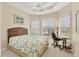 Inviting bedroom with a woven headboard, many windows, ceiling fan, and desk for a relaxing space at 105 Westwind Dr, Placida, FL 33946