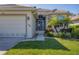 Inviting front entrance with tropical landscaping, a decorative front door, and a paved walkway at 105 Westwind Dr, Placida, FL 33946