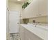 Functional laundry room features appliances, storage cabinets, and a tiled floor for efficiency and convenience at 105 Westwind Dr, Placida, FL 33946