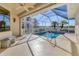 A screened-in pool area with a sparkling pool, view of the golf course, and bright sunlight shining through the enclosure at 105 Westwind Dr, Placida, FL 33946