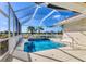 Enclosed screened-in pool area with palm trees and sunny sky at 105 Westwind Dr, Placida, FL 33946