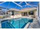 Sparkling screened-in pool with a geometric design is perfect for enjoying sunny days in your backyard at 105 Westwind Dr, Placida, FL 33946