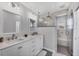 Beautiful bathroom featuring dual sinks, marble tile shower with glass door, and elegant light fixtures at 10500 Sherman St, Englewood, FL 34224