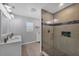 Bathroom with dual sinks and a glass-enclosed shower featuring a tiled niche for toiletries at 10500 Sherman St, Englewood, FL 34224