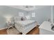 Comfortable bedroom featuring hardwood floors, two windows with blinds, and coastal-themed decor at 10500 Sherman St, Englewood, FL 34224
